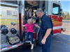 Firefighter helps girl out of fire truck