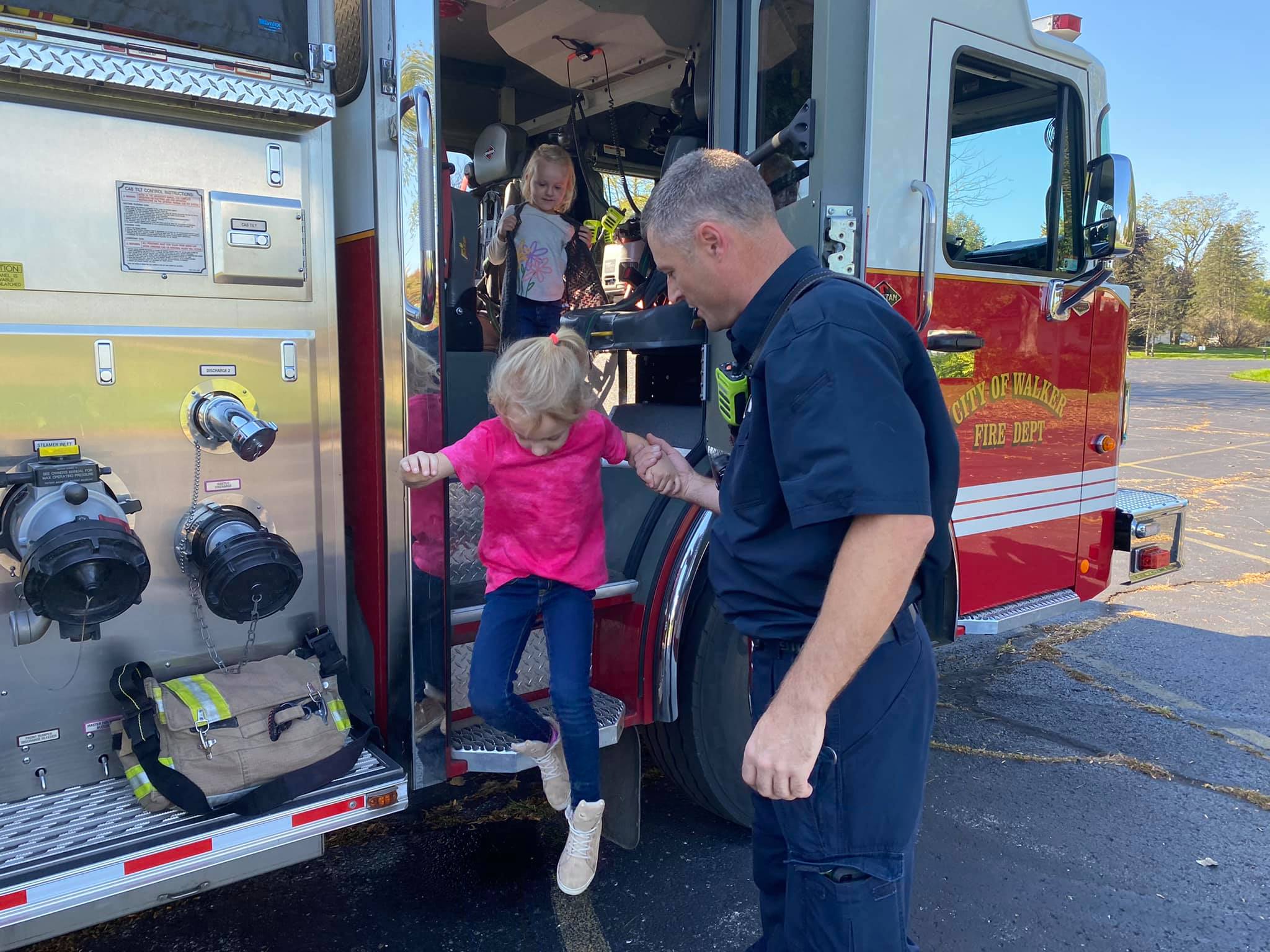 Firefighter helping child out of truck