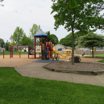 Kids playscape in a park with bikes leaning against it