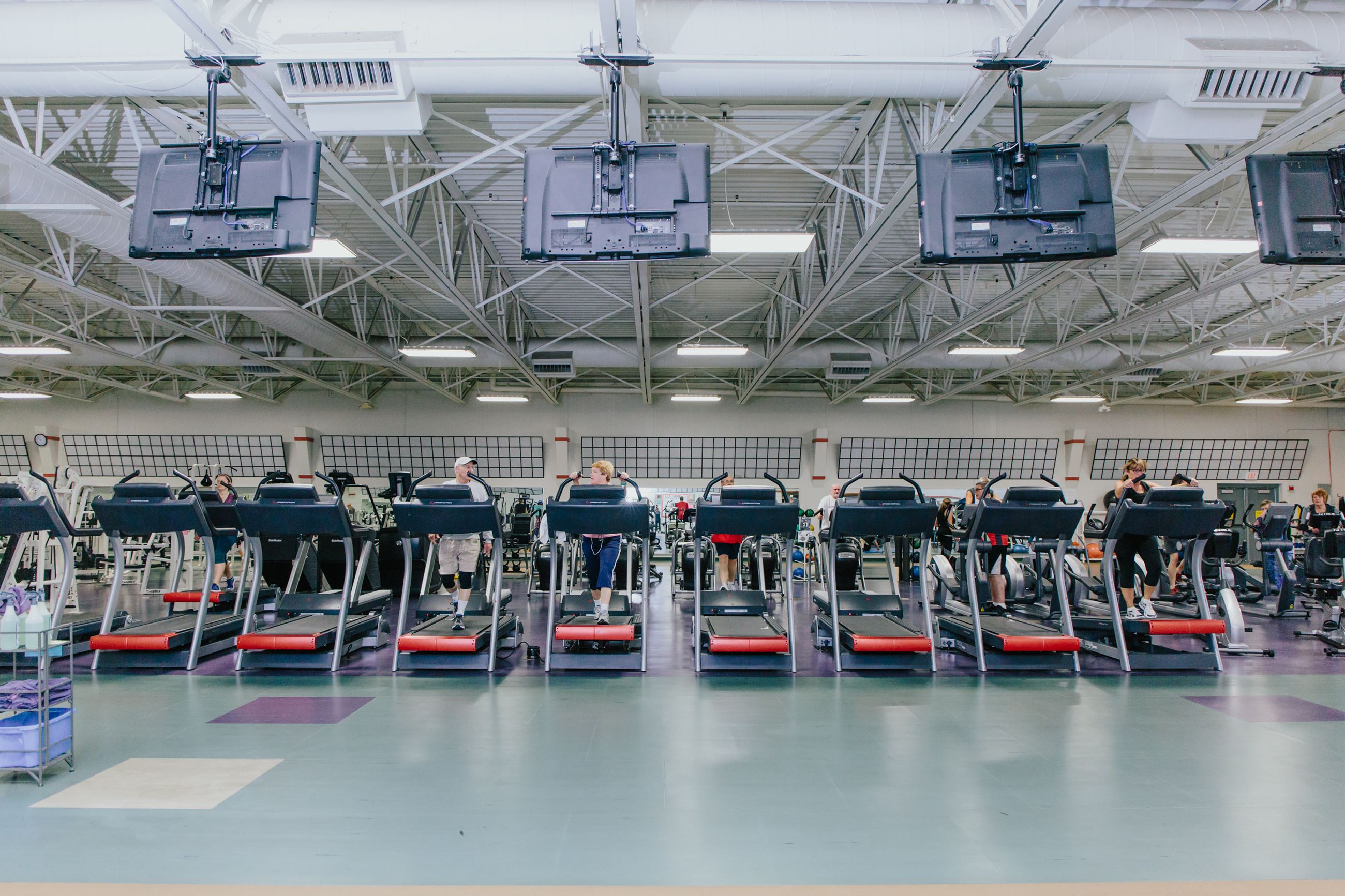 People chatting while using treadmills