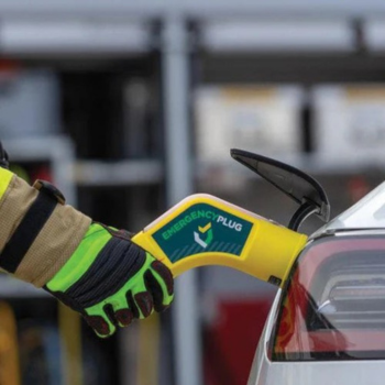 Firefighter holds eCar plug to car charging port to deactivate it