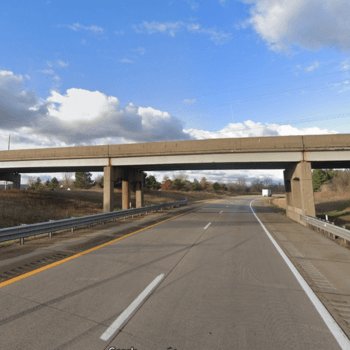 Blue skies with bridge over highway in background