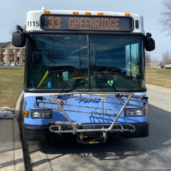 Front view of a transit bus in front of a bus stop