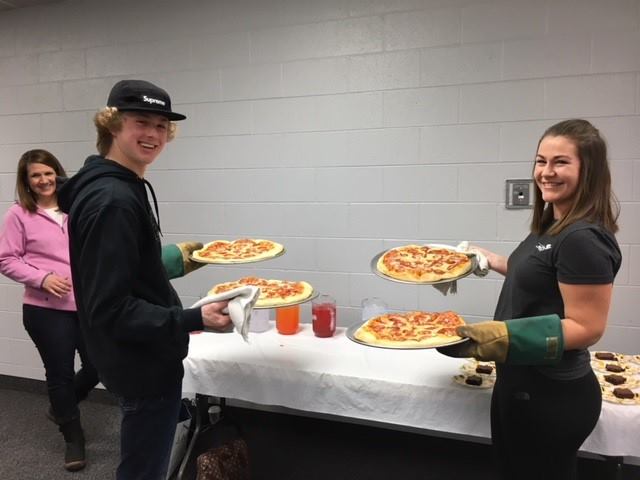 Young people serving up pizza